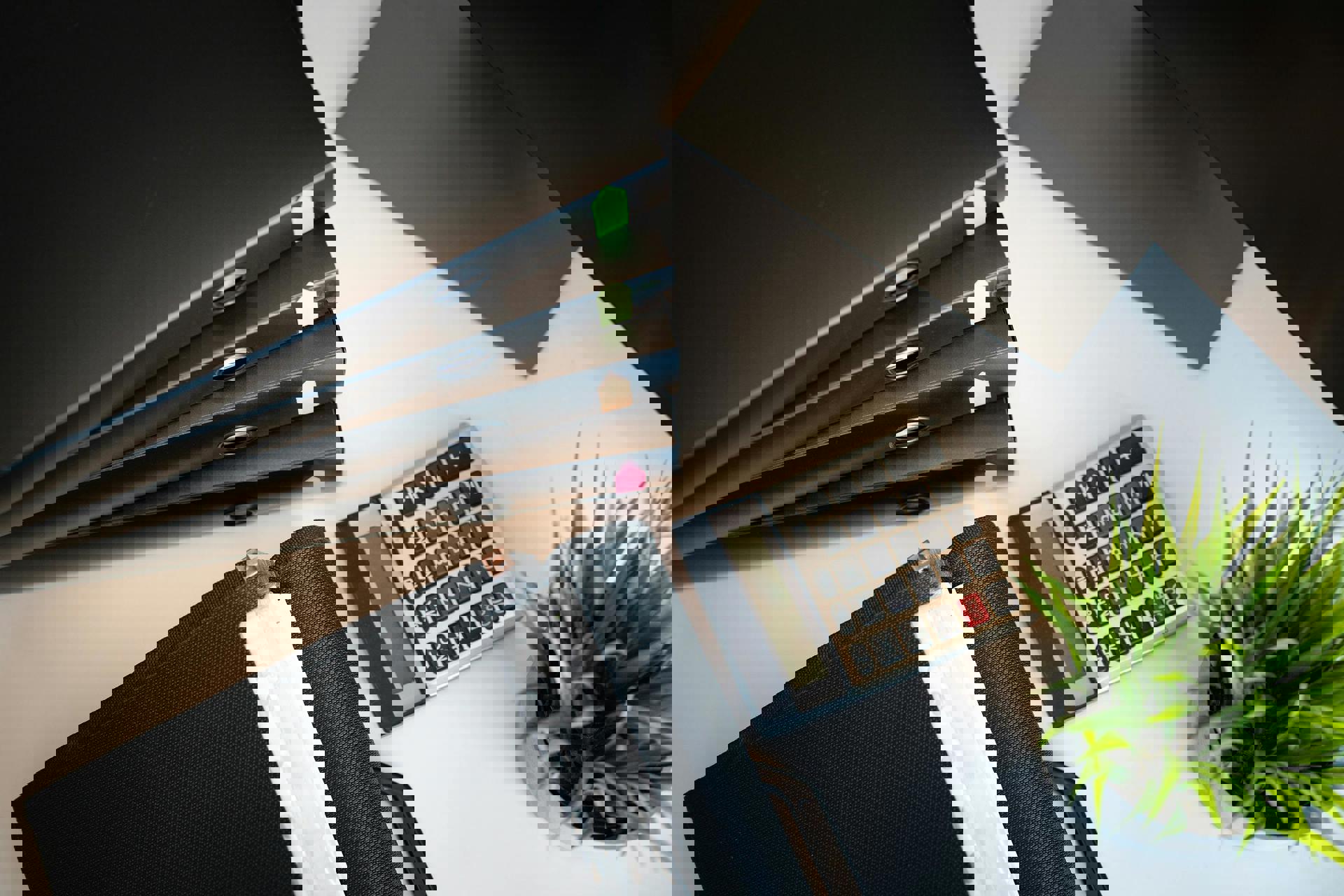 ein Taschenrechner und Ordner auf einem Tisch