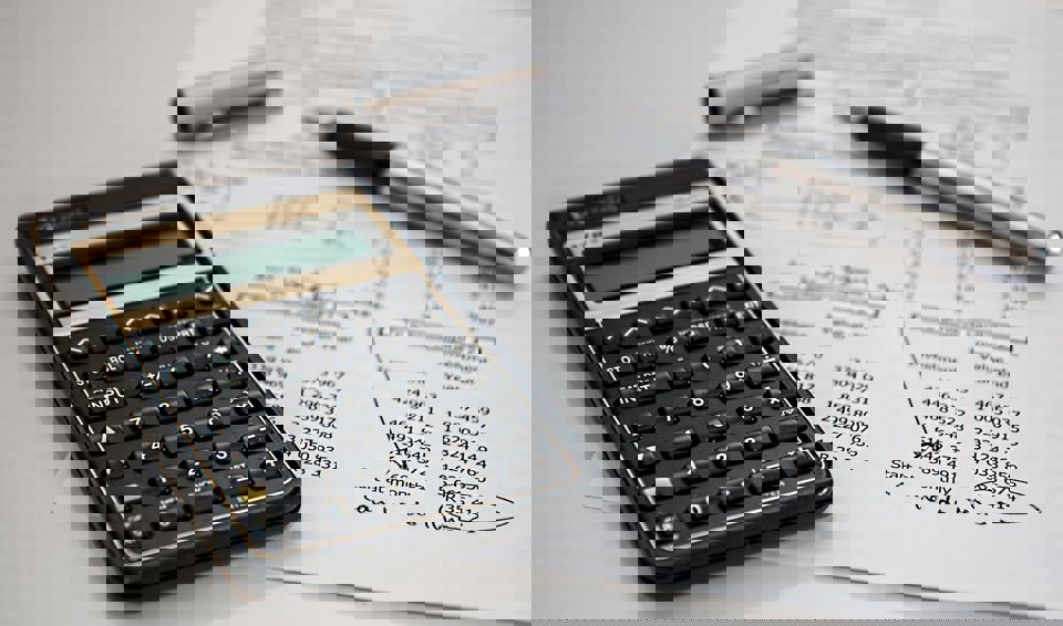 ein Taschenrechner und ein Stift auf einem Blatt Papier