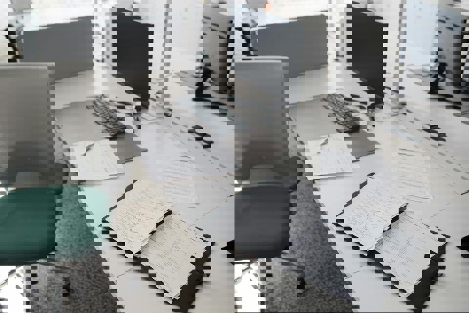 Ein Schreibtisch mit Papieren und einem Computer