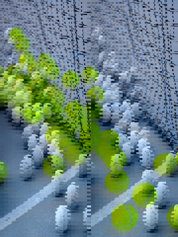 eine Gruppe von Tennisbällen auf einem Platz