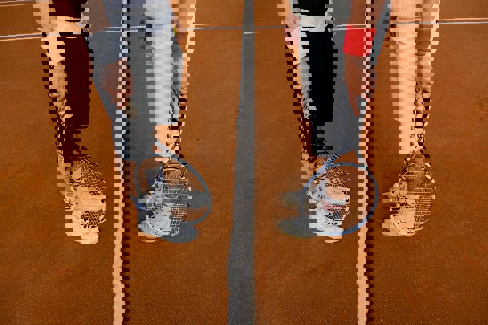 Zwei Personen, die Tennisschläger halten.