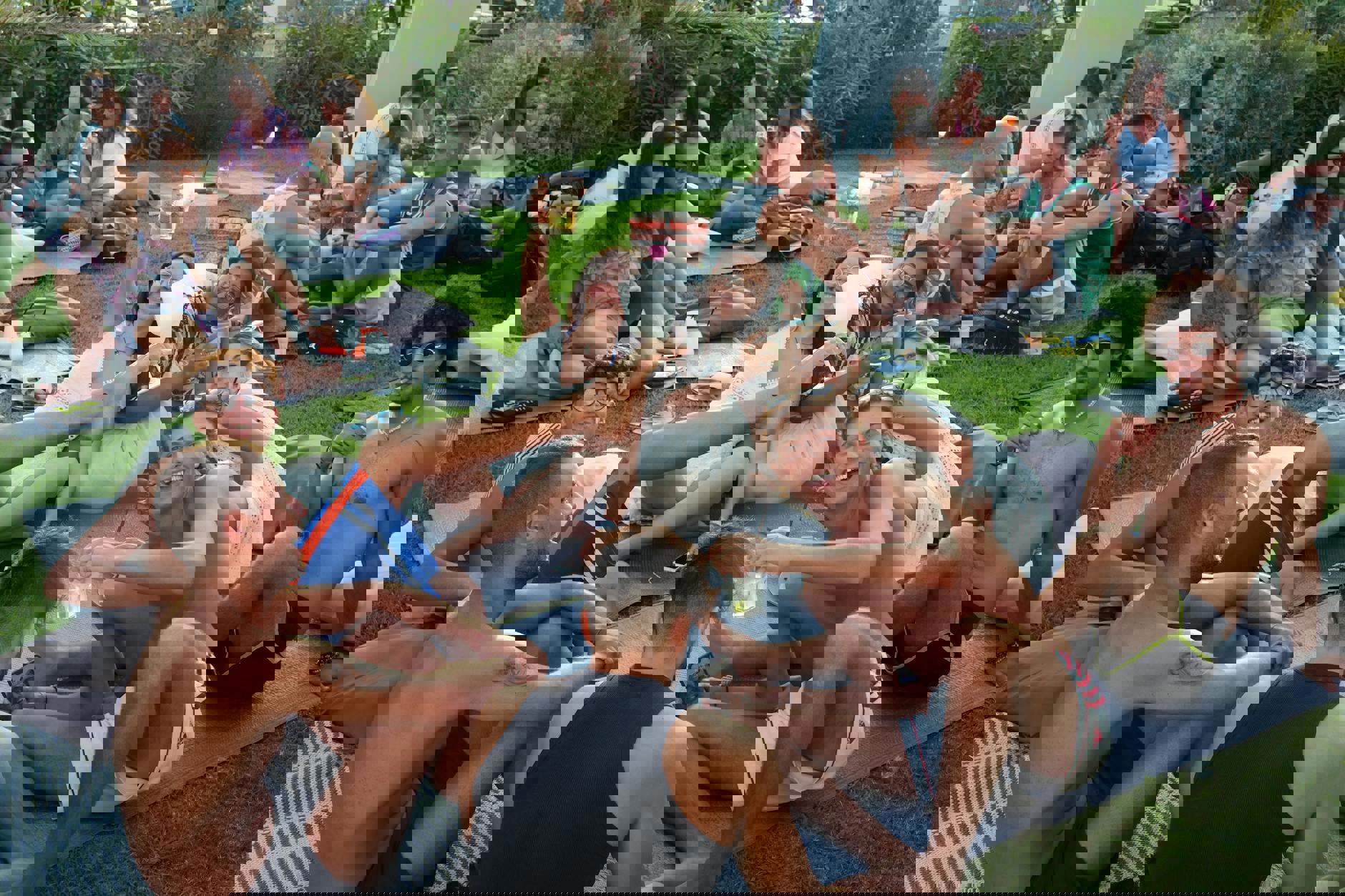 eine Gruppe von Menschen, die auf dem Gras sitzen