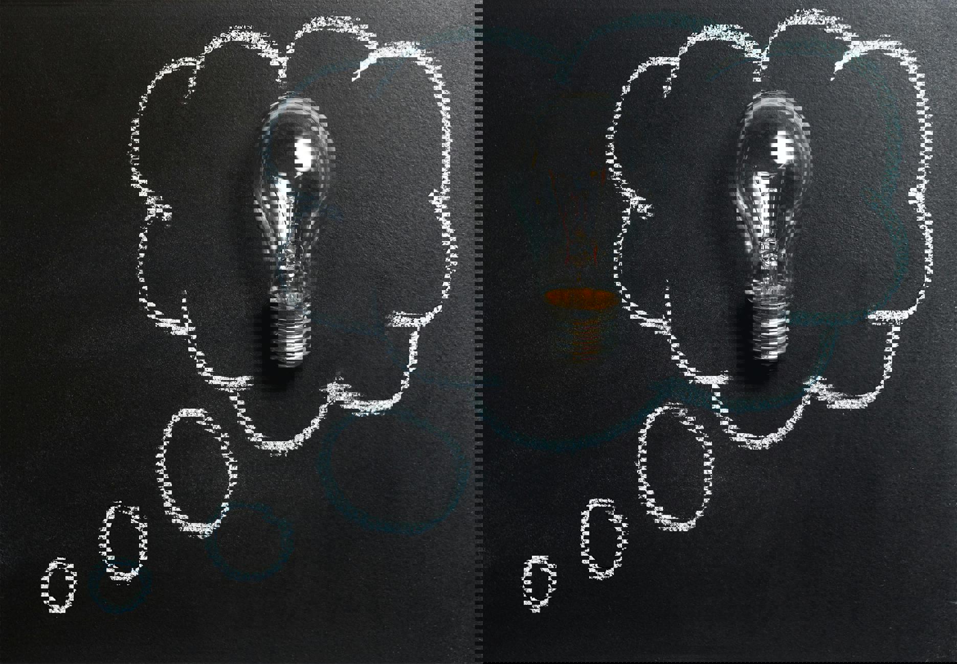 Eine Glühbirne mit einer Gedankenblase, die auf einer Tafel gezeichnet ist.