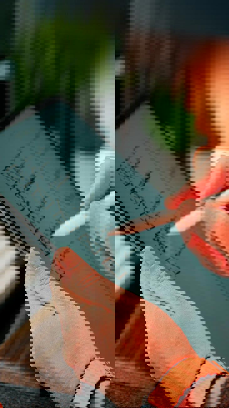 Eine Person hält ein Tablet mit einem Stift und einer Checkliste.