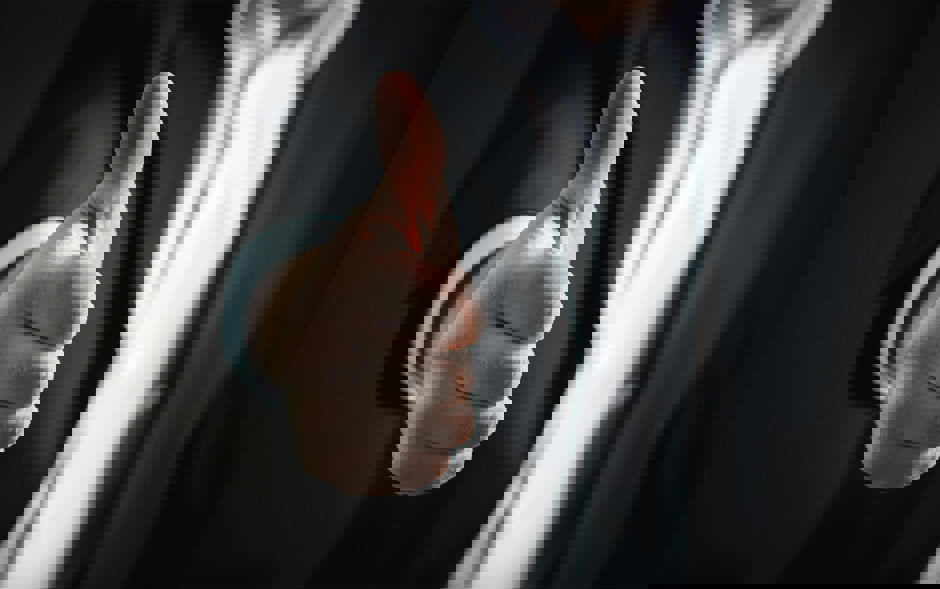 eine Nahaufnahme einer Hand, die einen Daumen nach oben zeigt